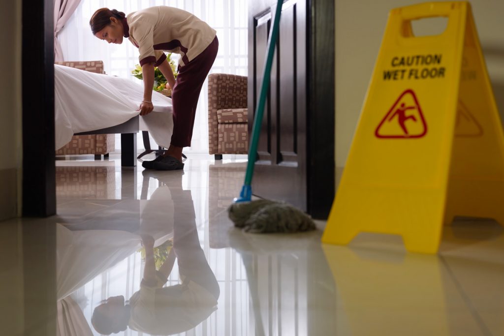 A woman cleans a hotel room.