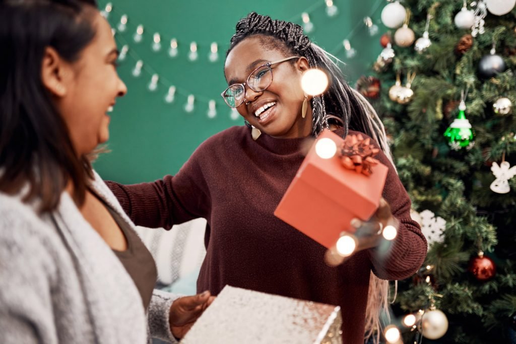 Two women hug while exchanging gifts on Christmas.