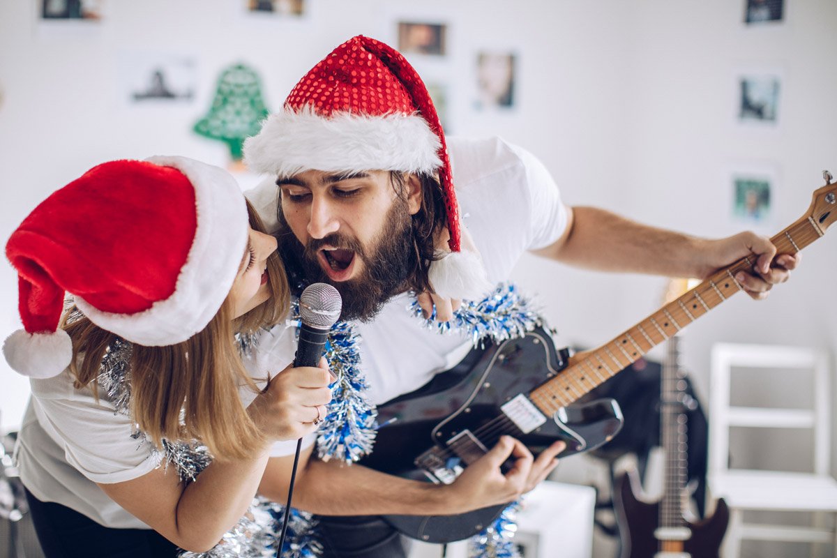 A couple sings songs together while one of them plays the guitar. 
