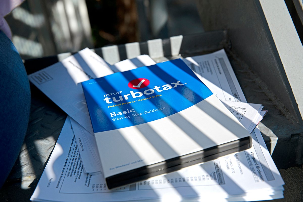 Woman sits a table doing taxes.