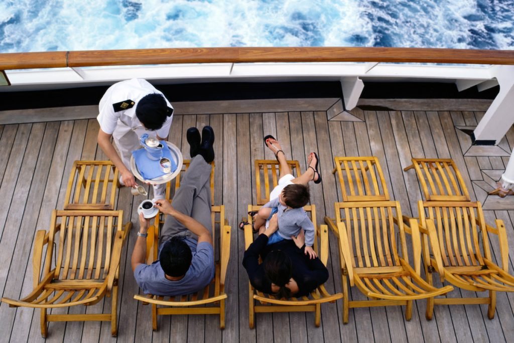 A cruise ship server gives people drinks on a cruise ship.