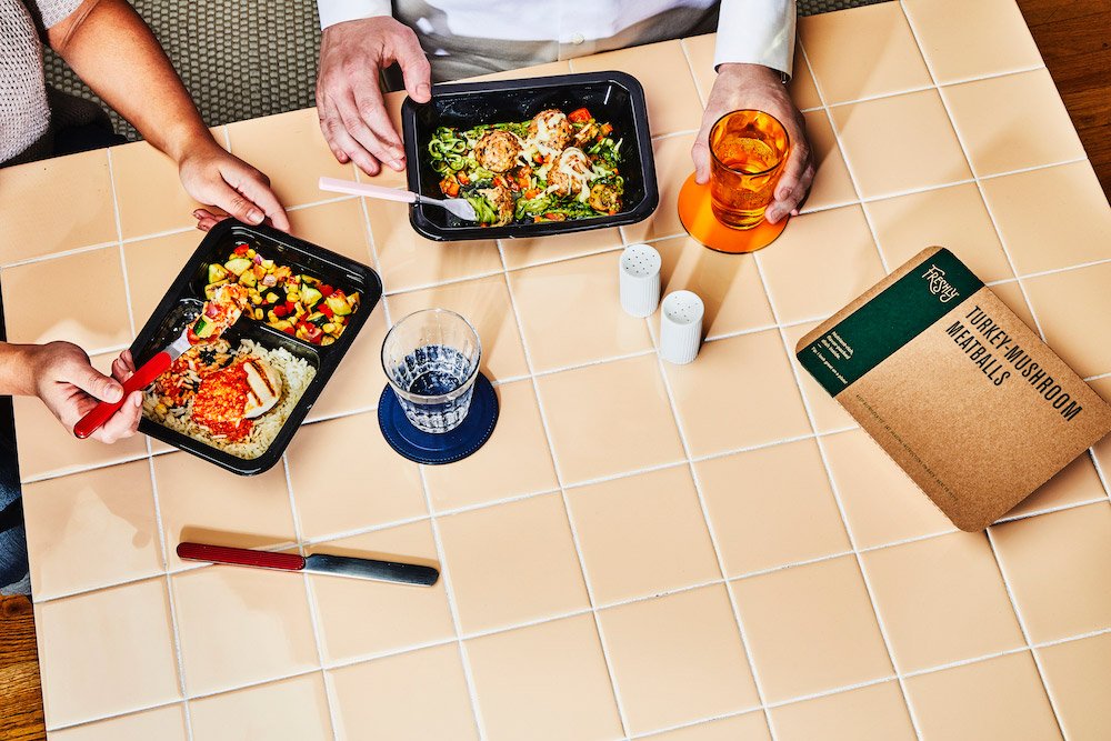 People eat a prepared meal from Freshly.