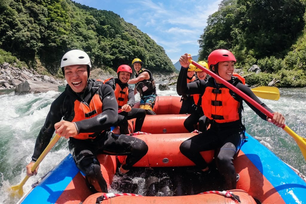 A group of people go rafting down a river.