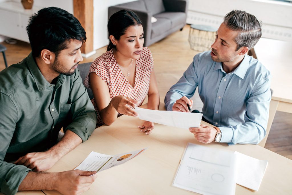 Two people go over paperwork with their lawyer.