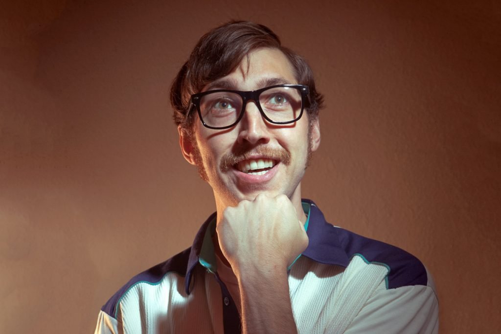 A man poses for a portrait in glasses.