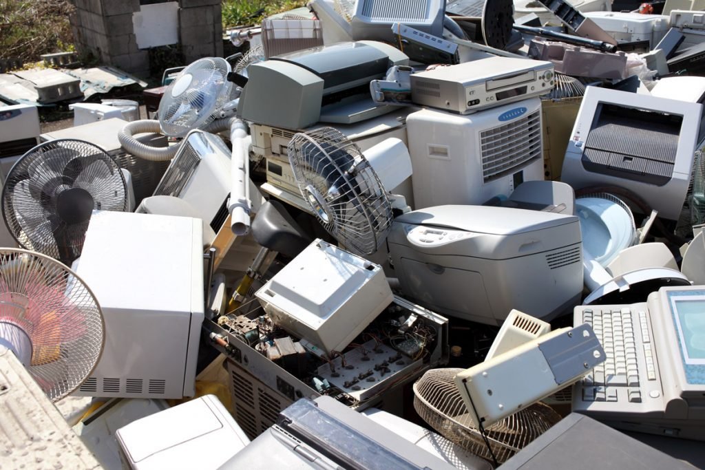A pile of old electronics sit in a pile.