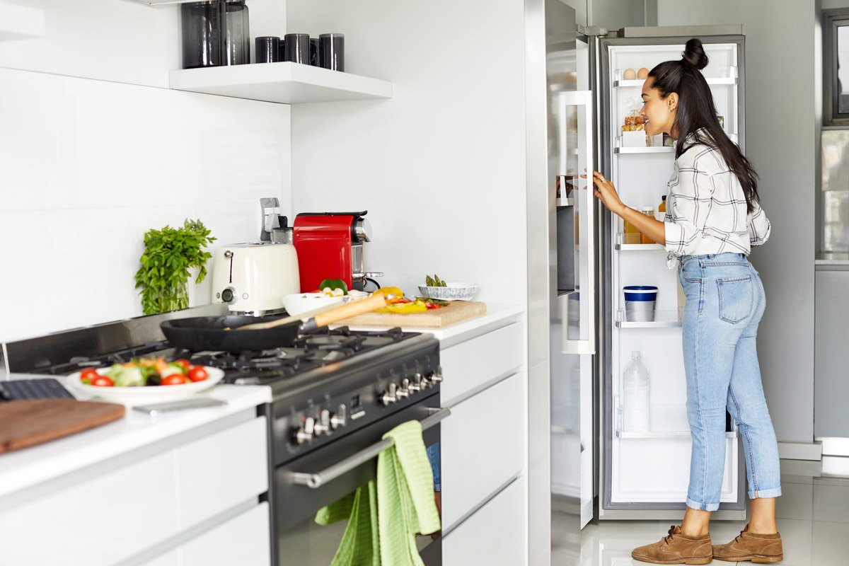 A woman opens up the fridge in her home.
