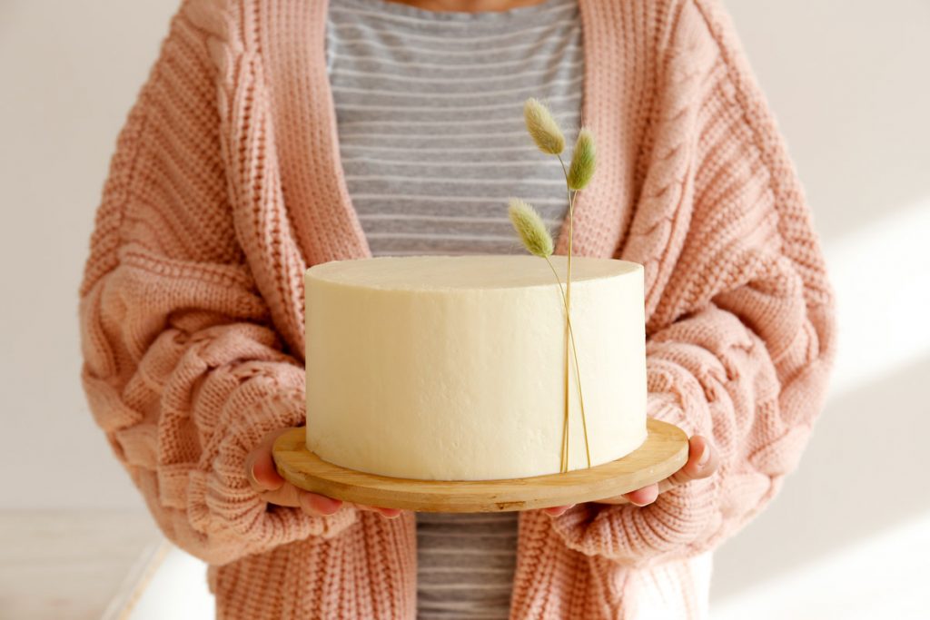 A person holds a wedding cake.