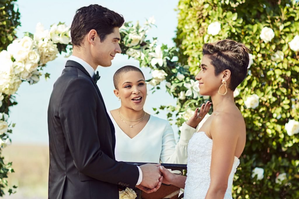 A friend marries the bride and groom at their wedding ceremony.