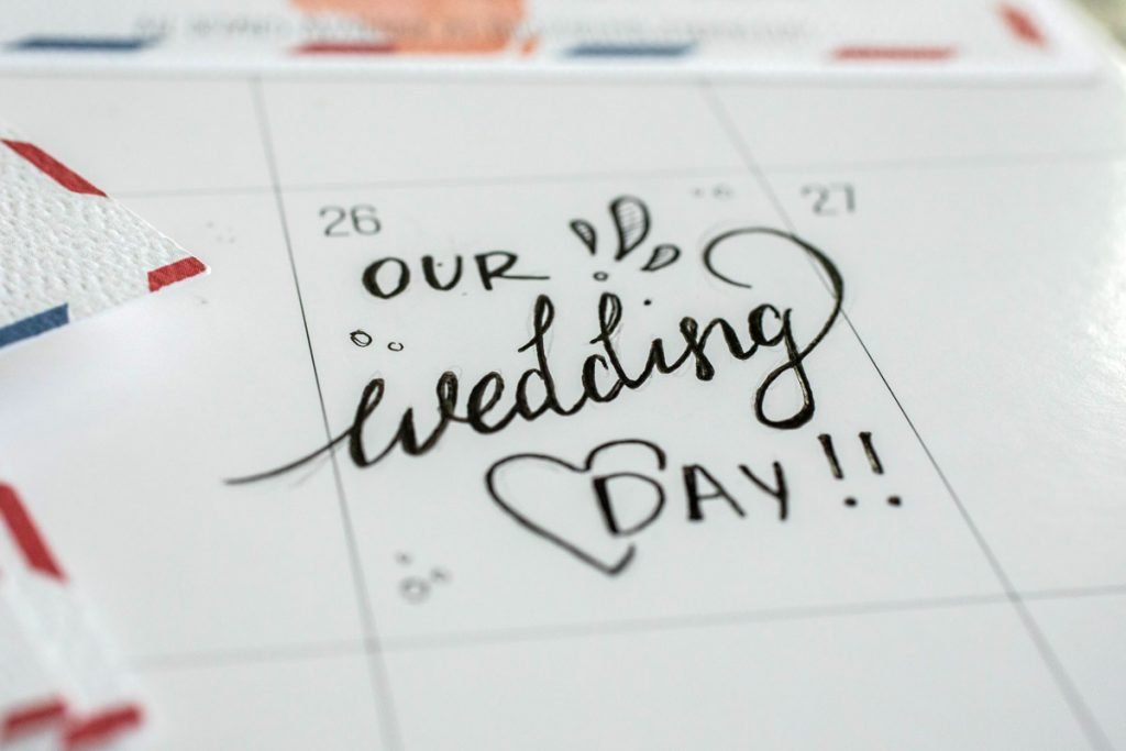A person write's on their calendar: Our Wedding Day.