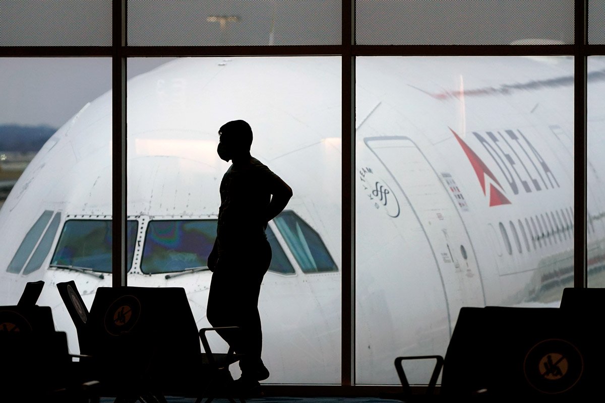 A passenger waits for a Delta Airlines flight at an airport. 