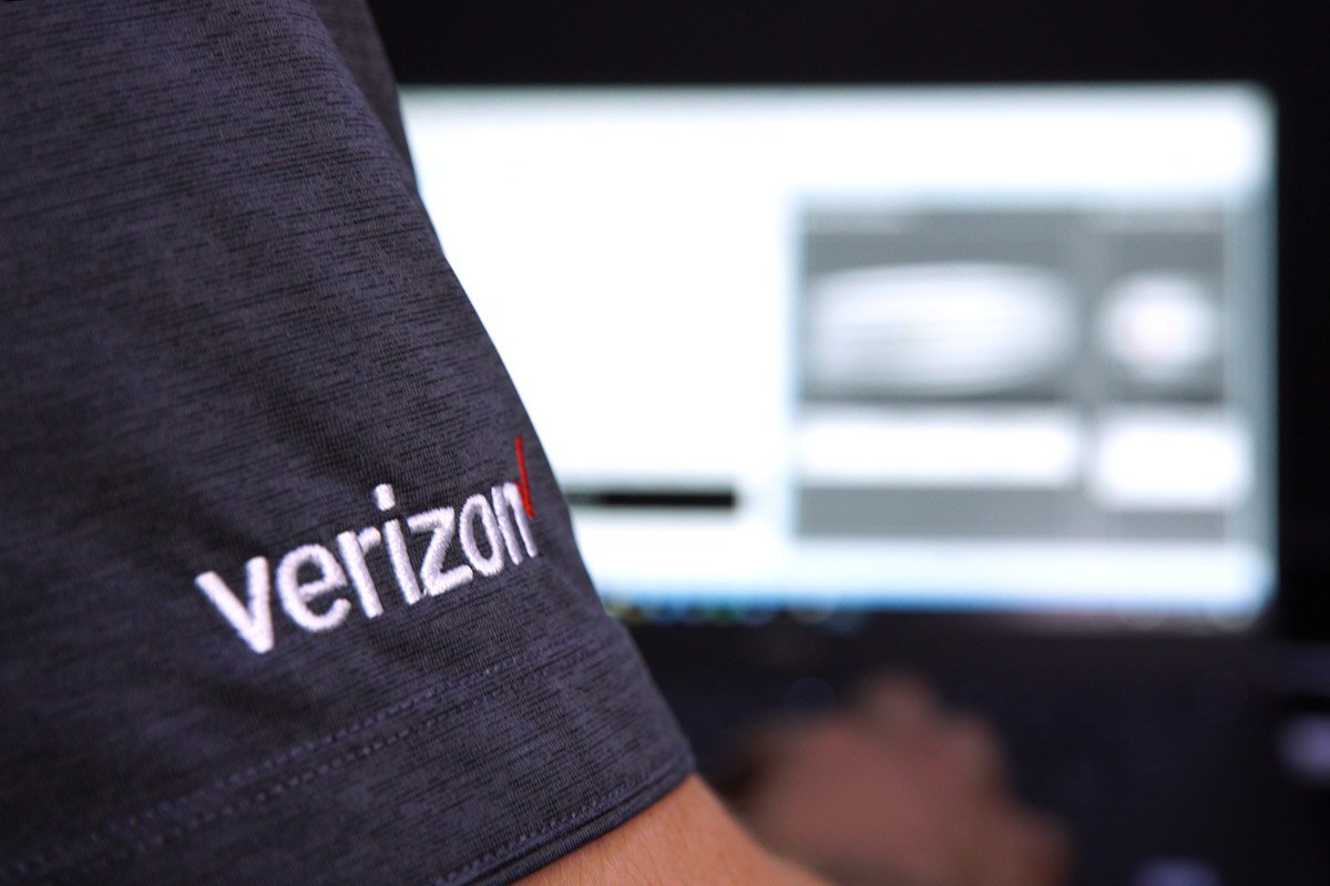 A man wears a Verizon shirt. 