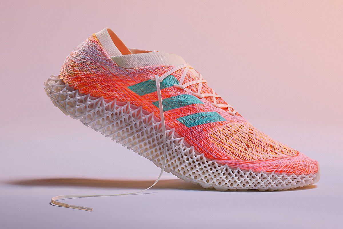 An Adidas shoe against a pink backdrop. 