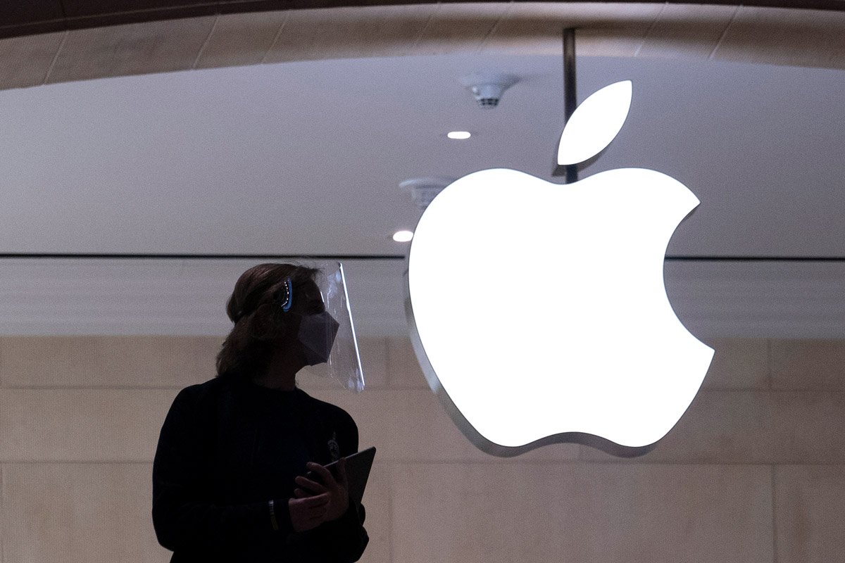 A silouhette of a woman is shown with the Apple logo in the background. 