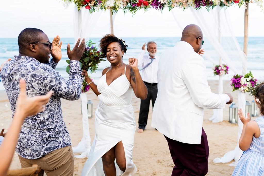 A couple dance on the beach after getting married. 