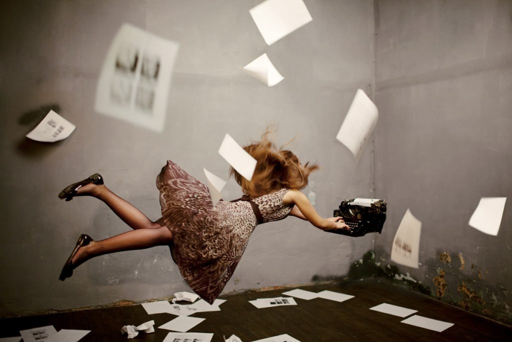 A woman types on a keyboard as her pages fly around her in this photo illustration.