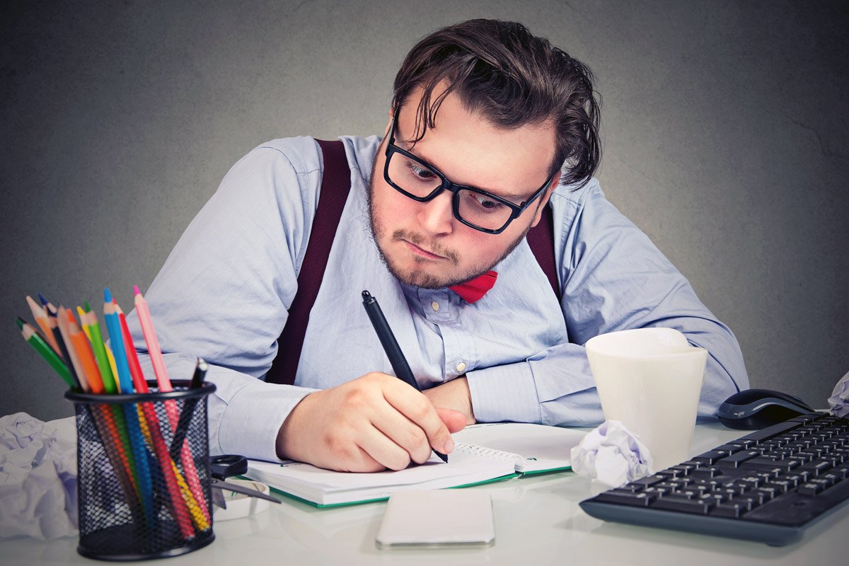 A man writes down something in his notebook. He is supposed to be a bookkeeper.