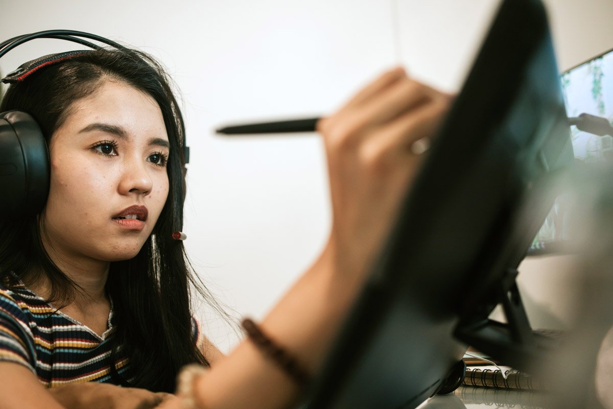 A woman draws on her computer.