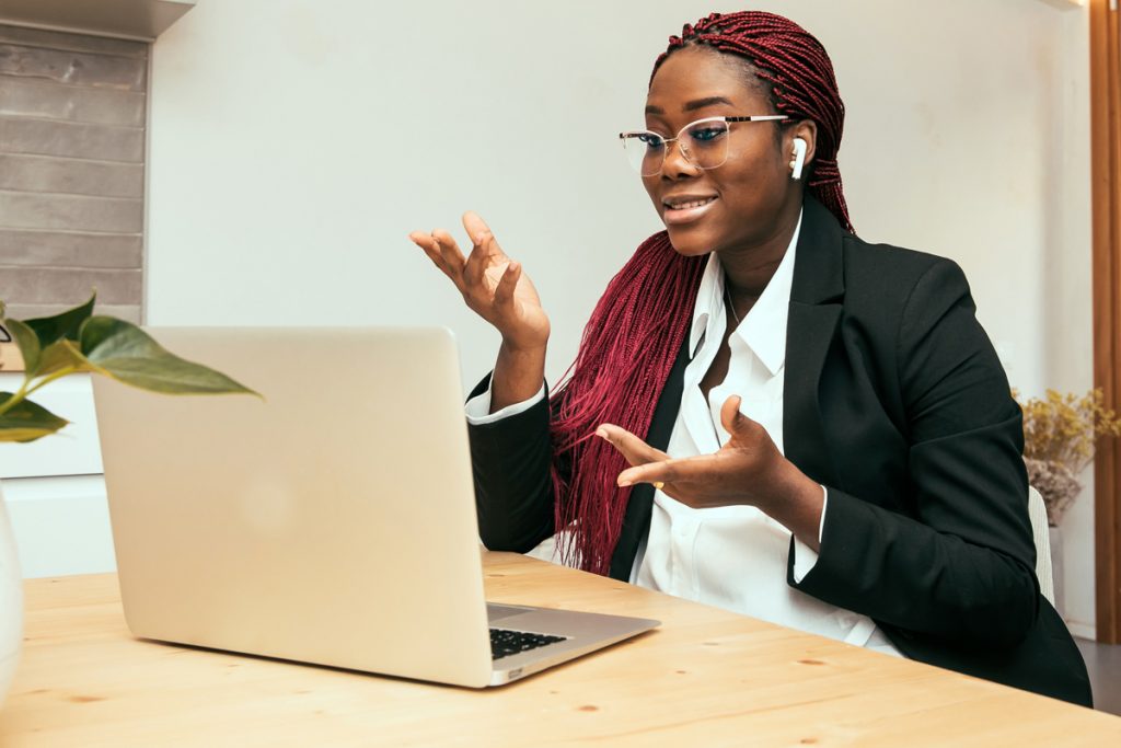 A woman takes a meeting as she works from home.
