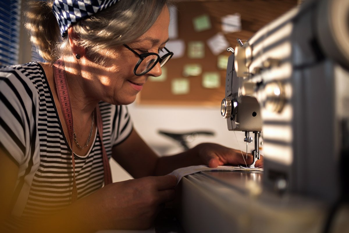 A woman sews in her home.