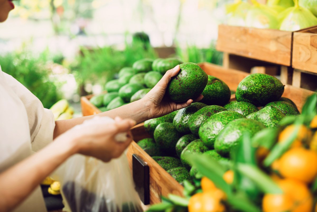 A woman picks spotty produce to go in her bag.