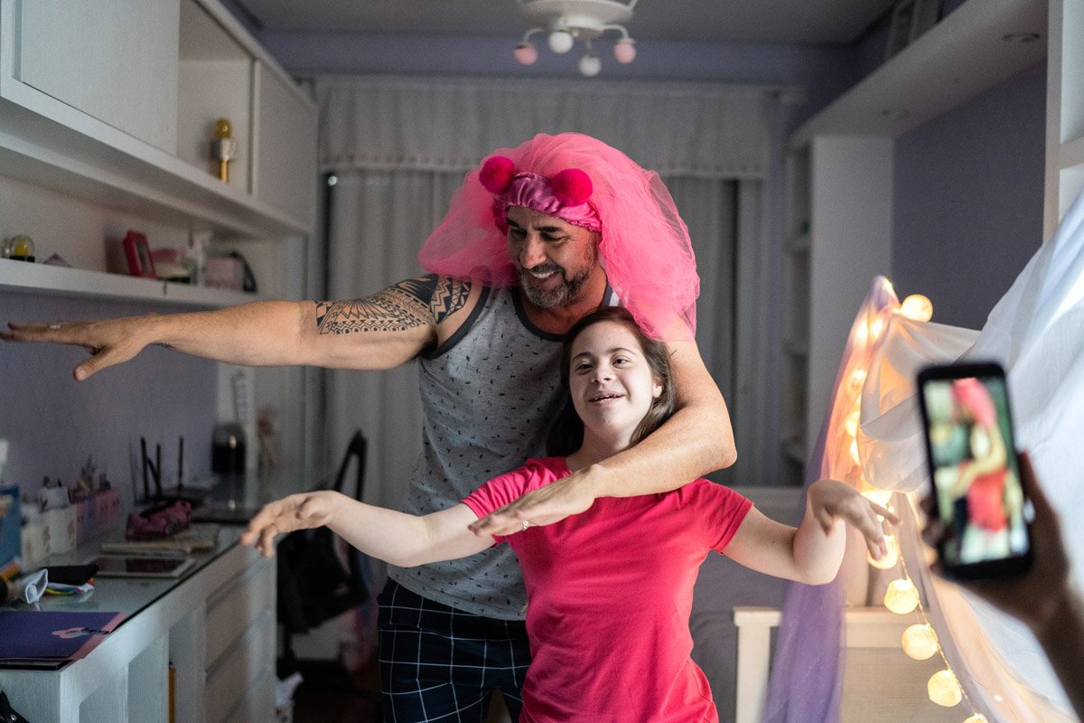 Two people dance while someone records them on a phone.