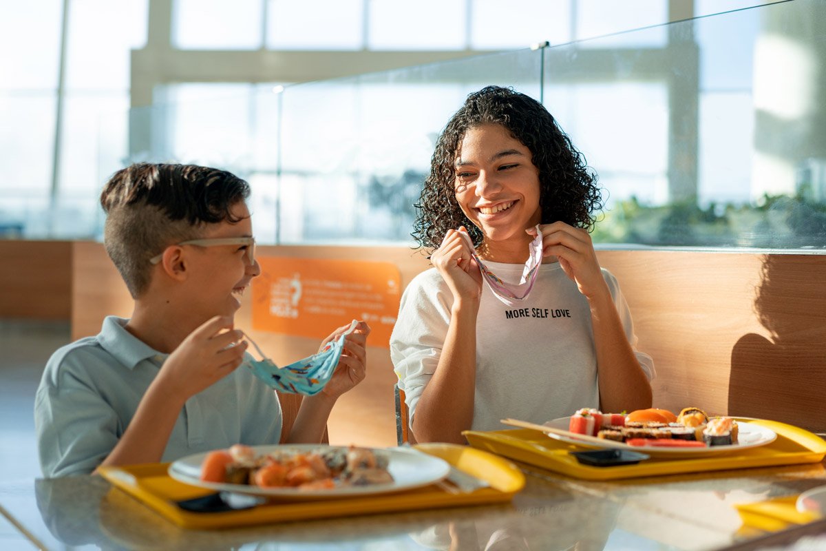Two children eat lunch.