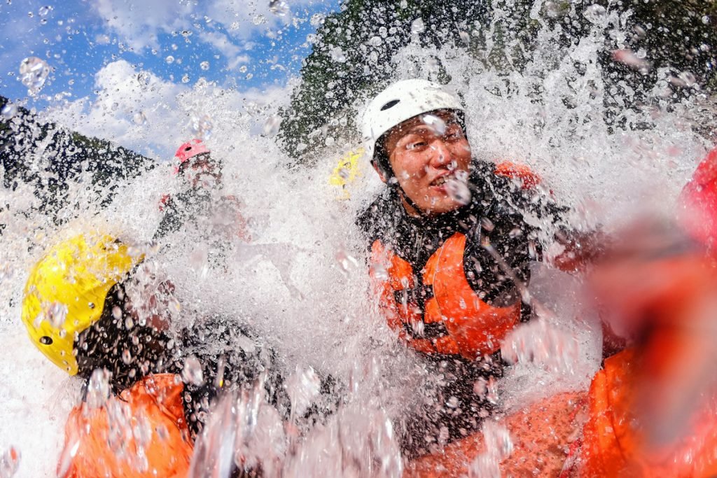 A group of people go whitewater rafting.
