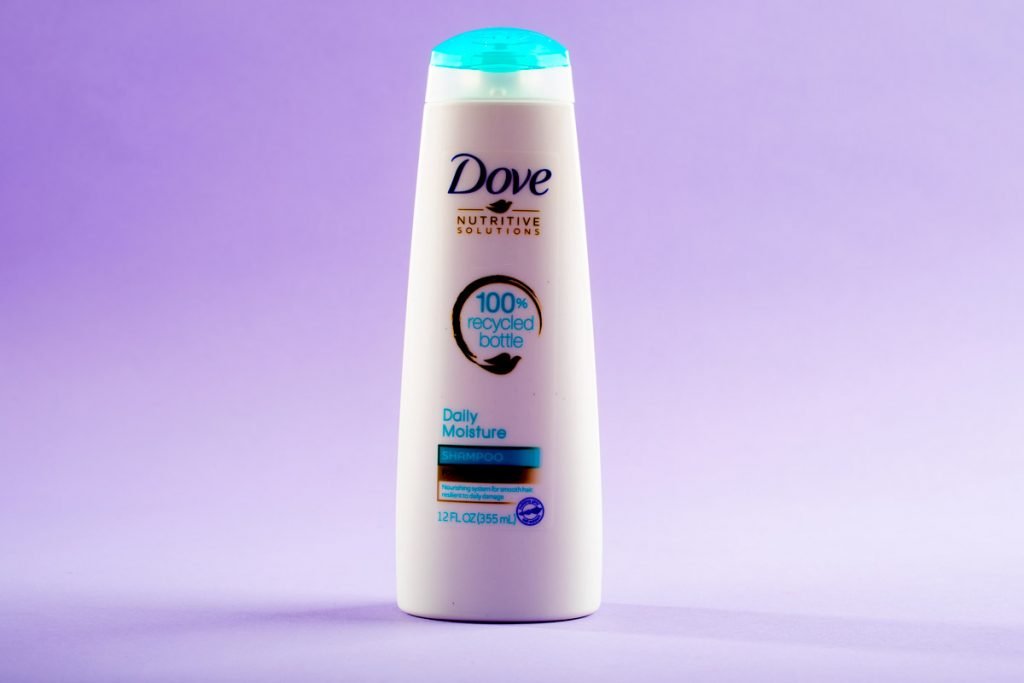 Dove Daily moisture shampoo is photographed against a purple background. 