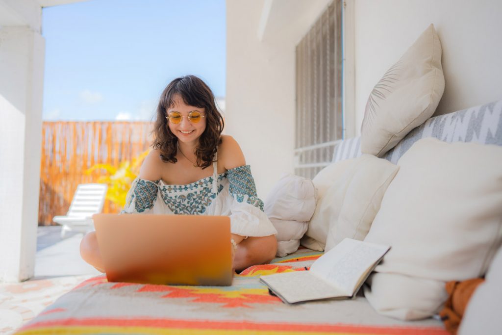 A woman does work on a porch at a house in Mexico. 