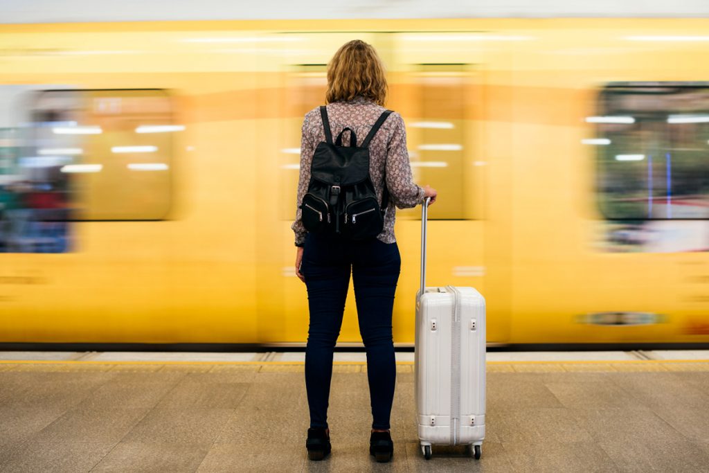 A woman waits for the subway to stop before boarding it. 